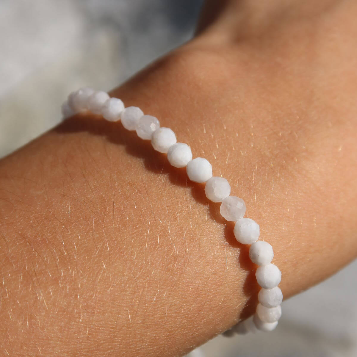 Regenbogen Mondstein Armband mit facettierten 4-6-8mm Perlen, schimmernde Farben auf Hand.