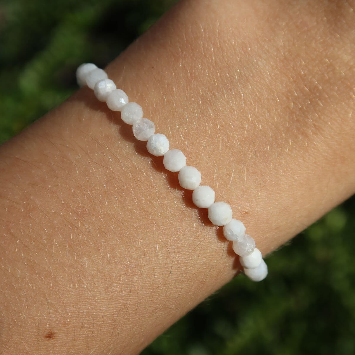 Regenbogen Mondstein Armband mit facettierten 4-6-8mm Perlen, schimmernde Farben auf Hand.