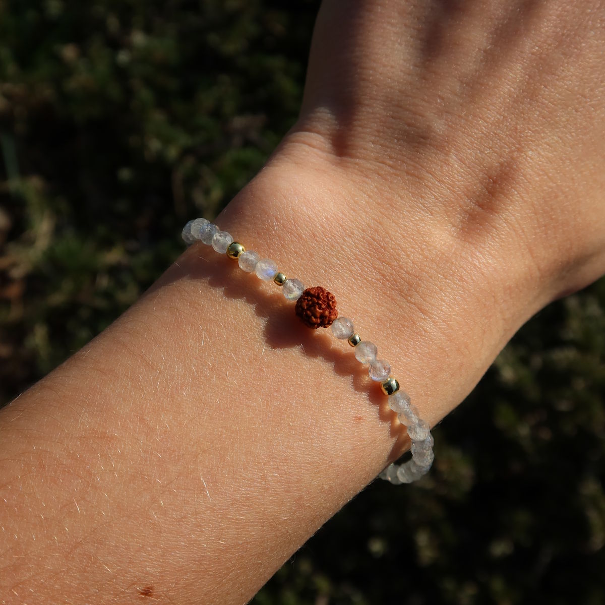 Labradorit mit Rudraksha Armband auf einem Handgelenk, kombiniert silberne und braune Elemente.