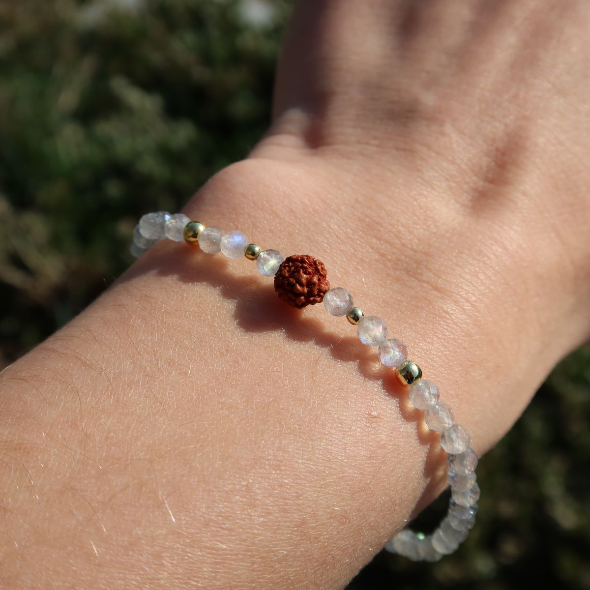 Labradorit mit Rudraksha Armband auf einem Handgelenk, kombiniert silberne und braune Elemente.