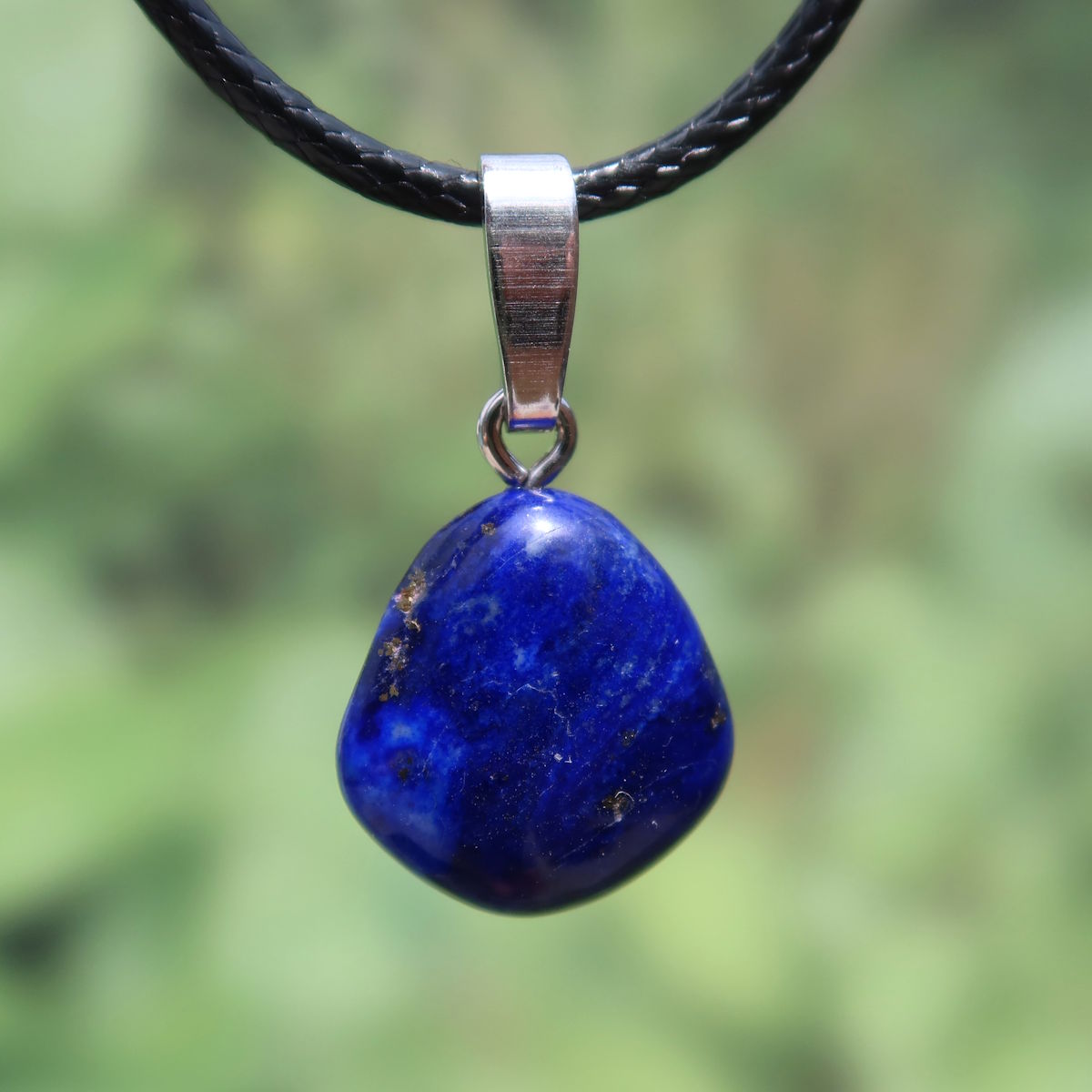 Handcrafted natural lapis lazuli pendant with silver rhodium-plated bail, featuring golden star-like flecks, unique jewelry.
