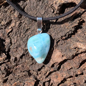 Echter Larimar Anhänger mit Silberschlaufe auf braunem Hintergrund, einzigartiger Edelstein aus der Dominikanischen Republik.