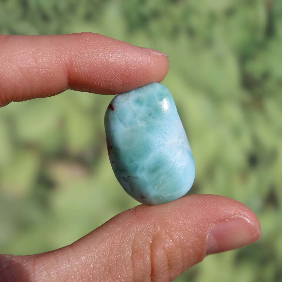 Echter Larimar Handschmeichler 26mm, einzigartiger Edelstein aus der Dominikanischen Republik, in der Hand gehalten.