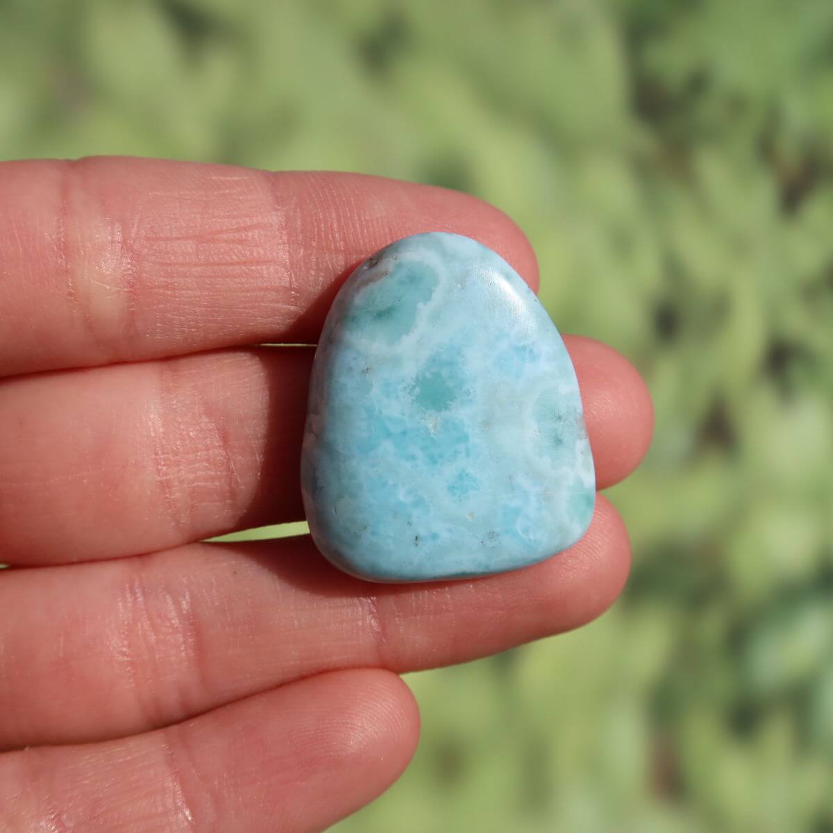 Hand holding a 27mm Echter Larimar stone, showcasing its unique blue hue and smooth surface, perfect for enhanced perception and protection.