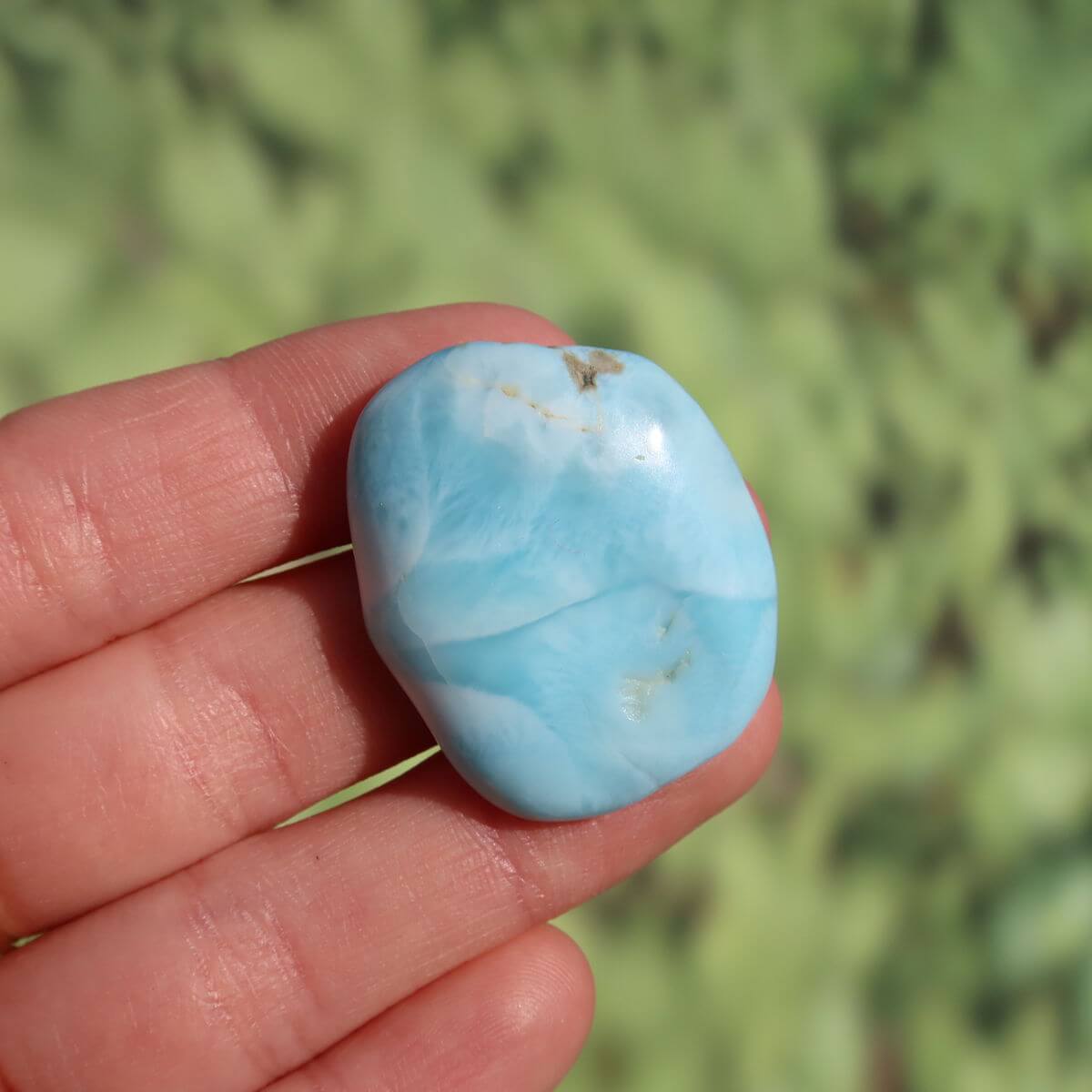 Echter Larimar Handschmeichler 32mm, einzigartiger Pektolith-Edelstein aus der Dominikanischen Republik in dunkler Hand.