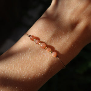 Handgemachtes Makramee Armband mit Sonnenstein - Lebensfreude und Selbstvertrauen - Nr. 6 auf einem Handgelenk.