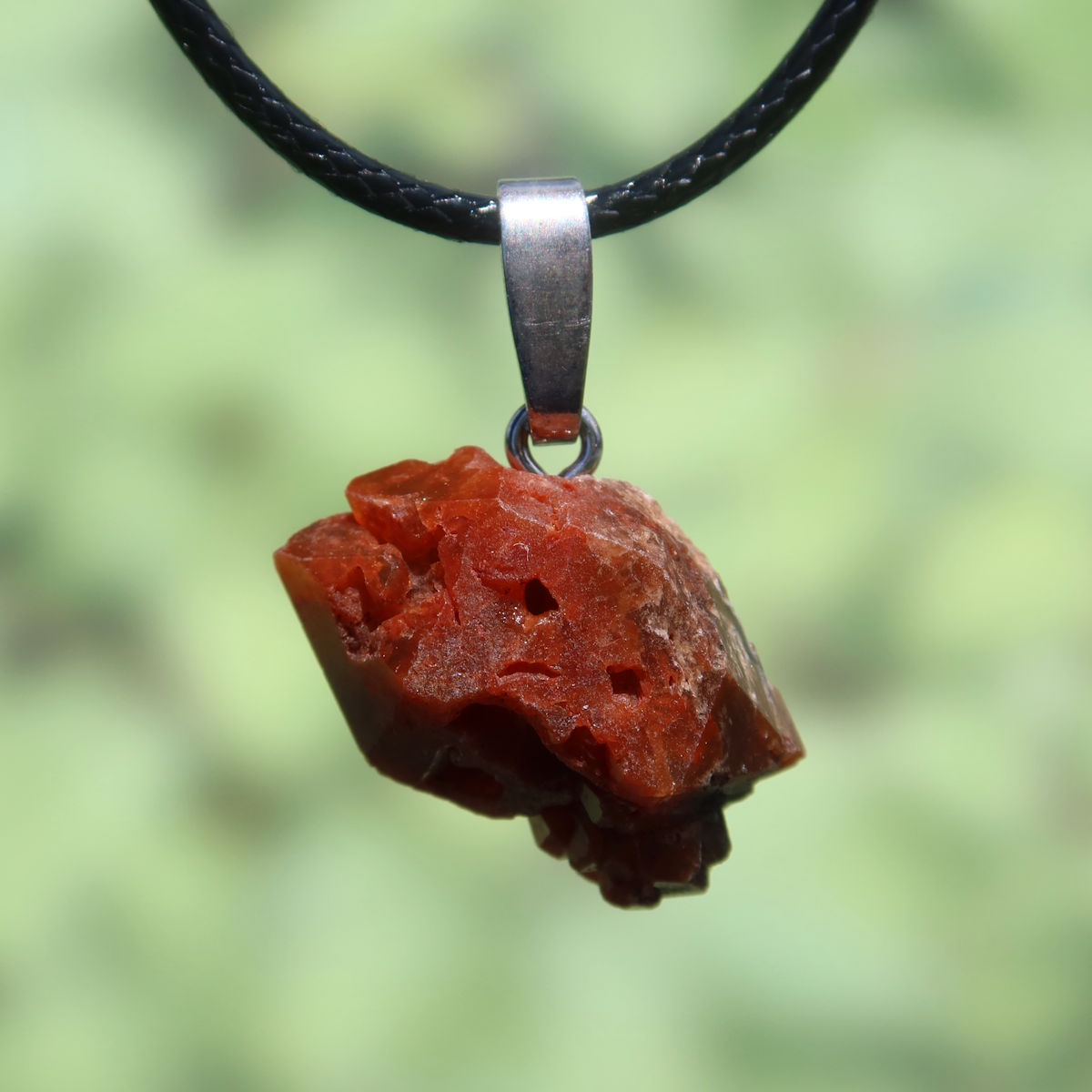 Roter, ungeschliffener Mondolith Anhänger mit Silberöse, ein einzigartiges Schmuckstück für Vitalität und Achtsamkeit.