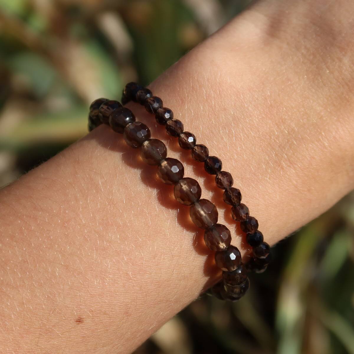 Faceted smoky quartz gemstone bracelet displayed on wrist, featuring natural, earthy beads highlighting the stone's calming properties.