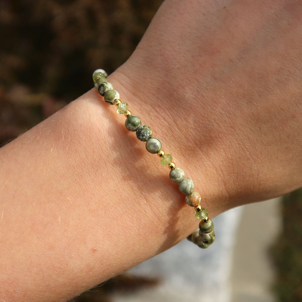 Handcrafted Rhyolith Rainforest Stone and Peridot gemstone bracelet, 17cm, showcasing faceted beads on wrist.