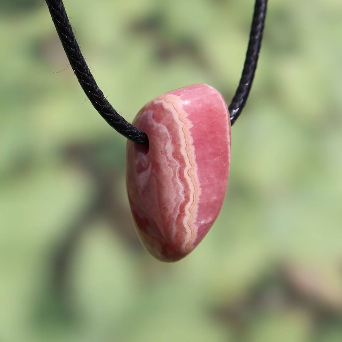 Rhodochrosit Anhänger an schwarzem Band, 1A Qualität, aus Argentinien. Einzigartige rosa Rot-Maserung. Jetzt online kaufen bei Steinwelten.