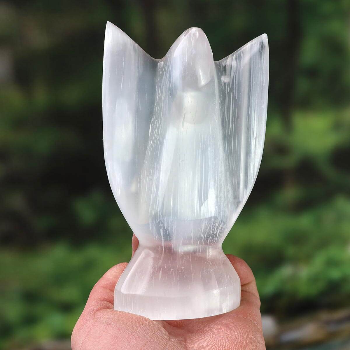 Hand holding a polished 15cm Selenite stone angel, a protective and light-bringing gemstone, available for purchase online in Graz.
