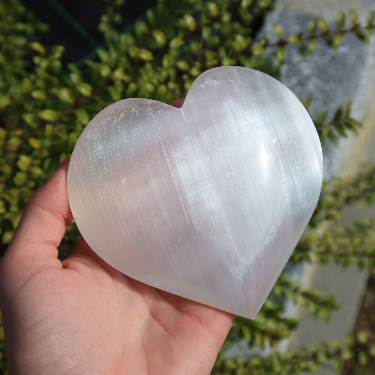 Selenit Herz - Handschmeichler - 10cm - Schutzstein für Stabilität und Nervenstärkung in einer Hand gehalten
