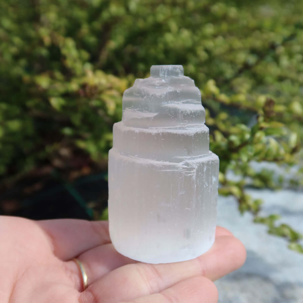 Natürlicher Selenit Kristall Turm 6cm (Marienglas, Gips) - Ein Lichtbringer und Schutzstein, auf einer Hand im Freien.