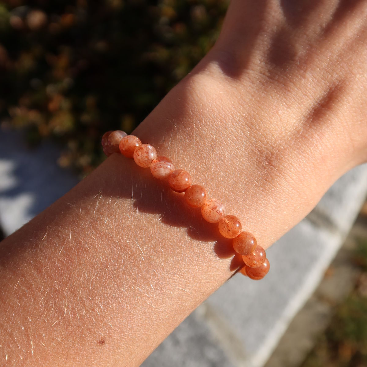 Sonnenstein Edelstein Armband - 1 Stück - in Varianten 4-5-6 oder 8mm, strahlend auf einem Handgelenk in der Sonne