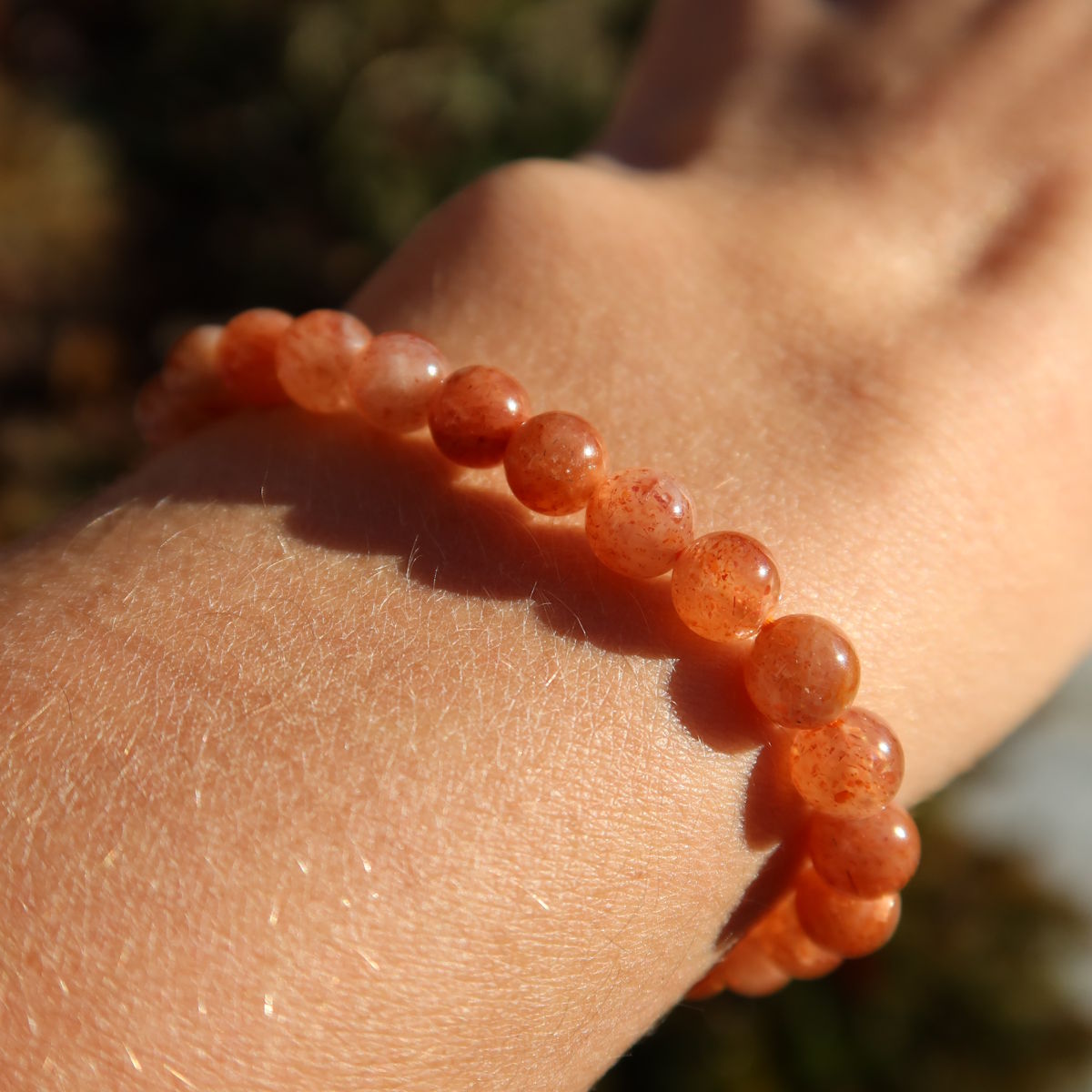 Sonnenstein Edelstein Armband - 1 Stück - in Varianten 4-5-6 oder 8mm, strahlend auf einem Handgelenk in der Sonne