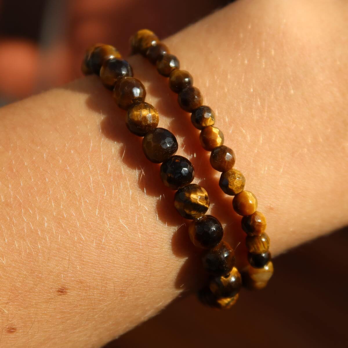 Faceted tiger's eye gemstone bracelets worn on wrist, showcasing 4mm to 8mm beads, ideal for focus and clarity.