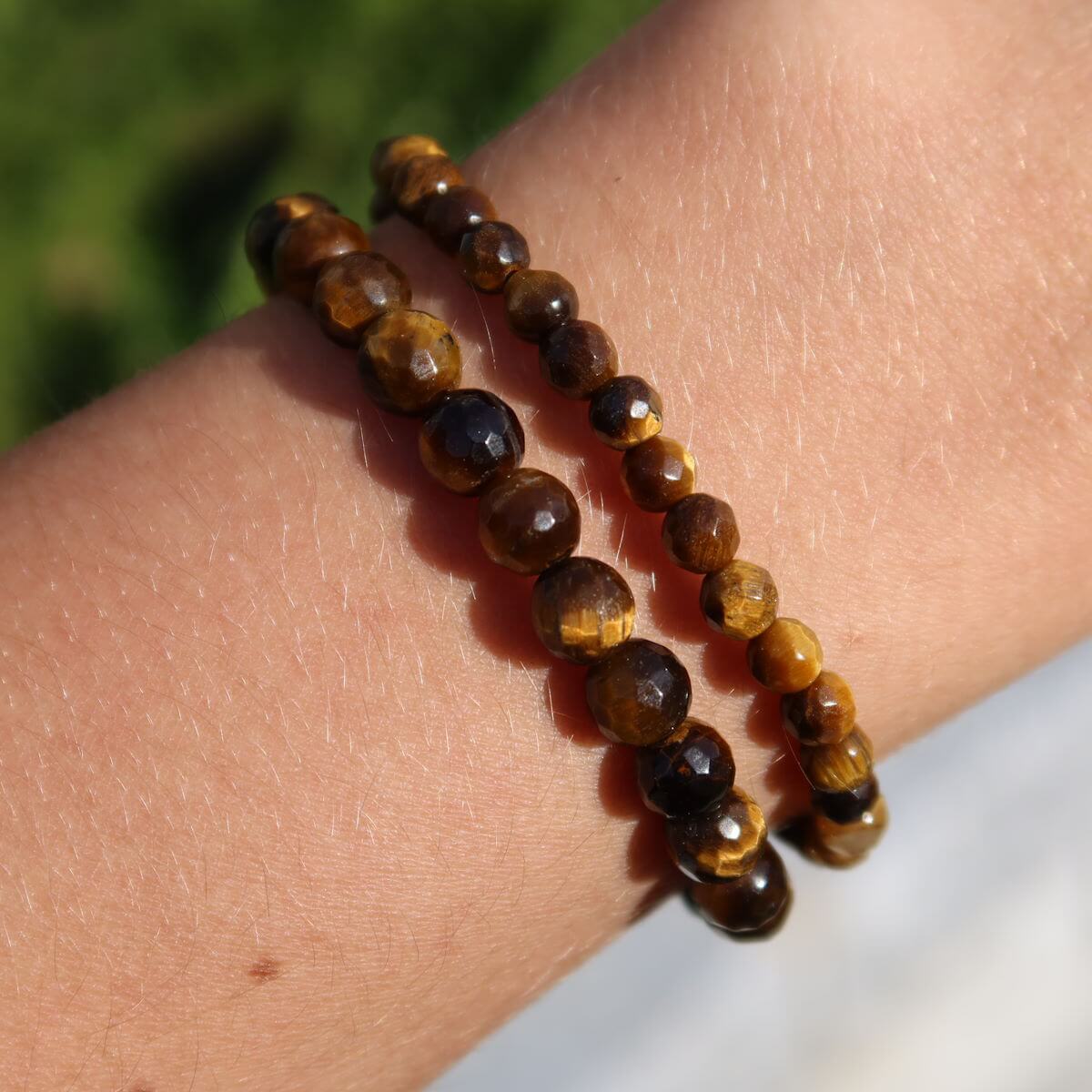 Faceted tiger's eye gemstone bracelets worn on wrist, showcasing 4mm to 8mm beads, ideal for focus and clarity.