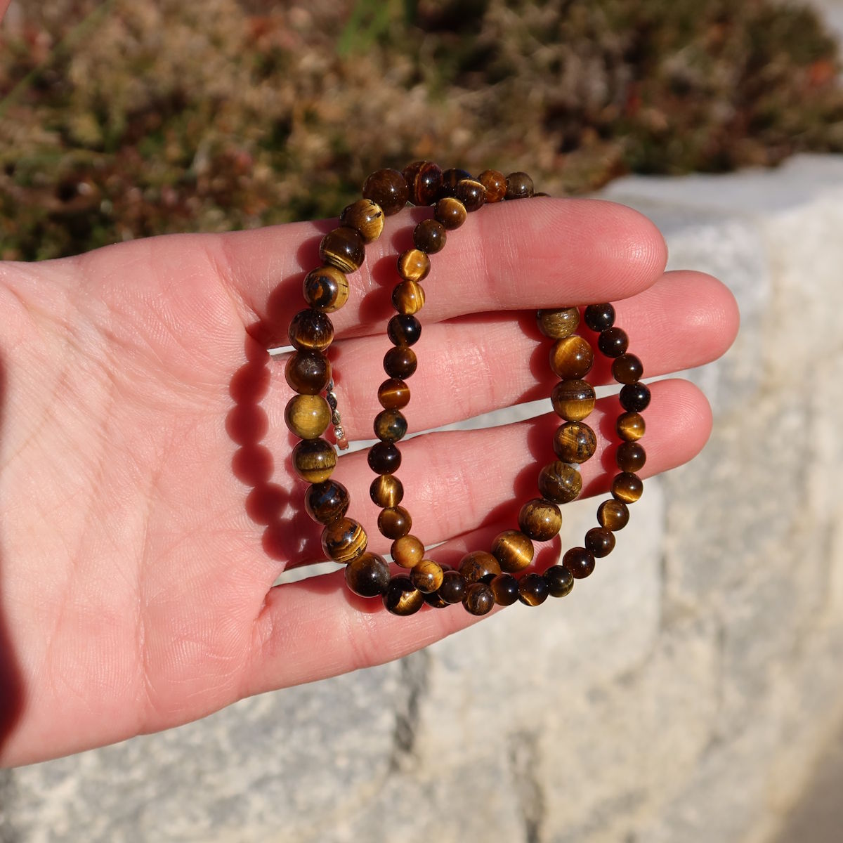 Tigerauge Edelstein Armband für schmale Handgelenke in Varianten 4-6 oder 8mm, auf Hand präsentiert.
