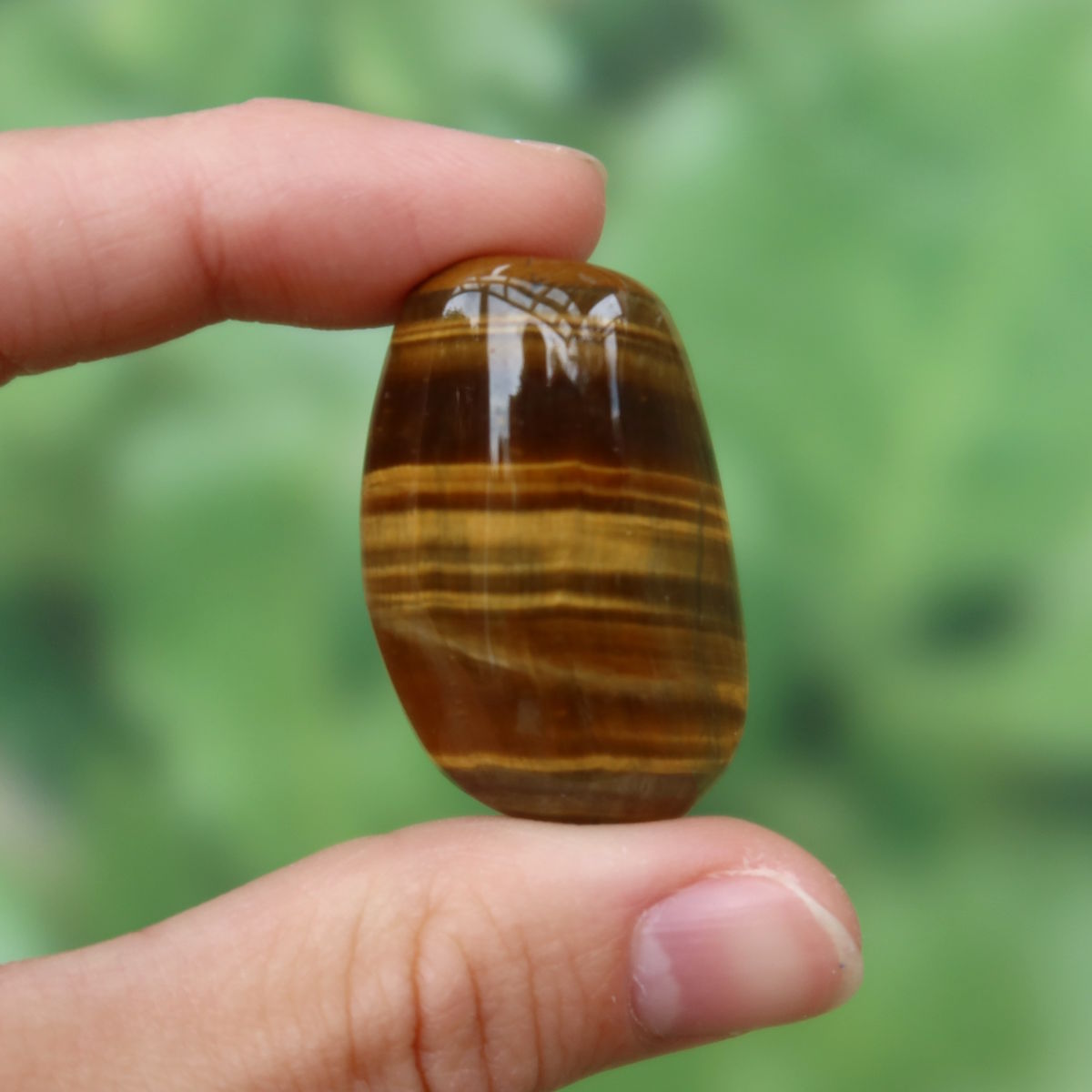 Tigerauge Handschmeichler 33mm - Selbstbewusstsein und Konzentration - Unikat Nr. 25, brauner Stein in Hand gehalten