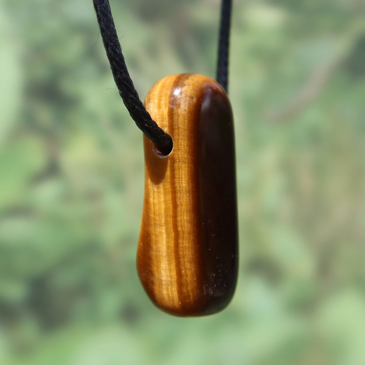 Tigerauge gebohrt - Selbstbewusstsein und Konzentration - UNIKAT Nr. 13 Anhänger mit markantem Schimmer und Streifen auf schwarzer Kordel.