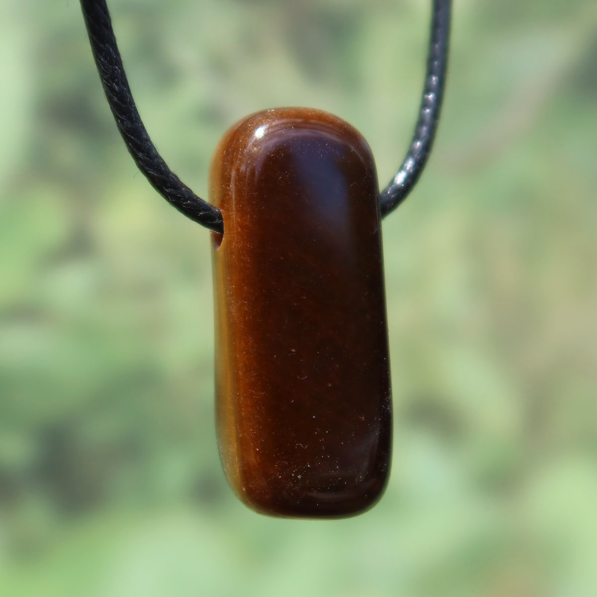 Tigerauge gebohrt - Selbstbewusstsein und Konzentration - UNIKAT Nr. 13 Anhänger mit markantem Schimmer und Streifen auf schwarzer Kordel.