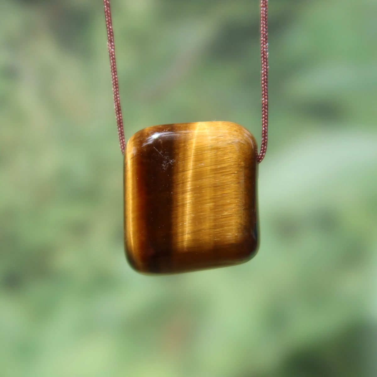 Tigerauge gebohrt - Selbstbewusstsein und Konzentration - UNIKAT Nr. 2 Anhänger mit glänzendem Schimmer und markanten Streifen.