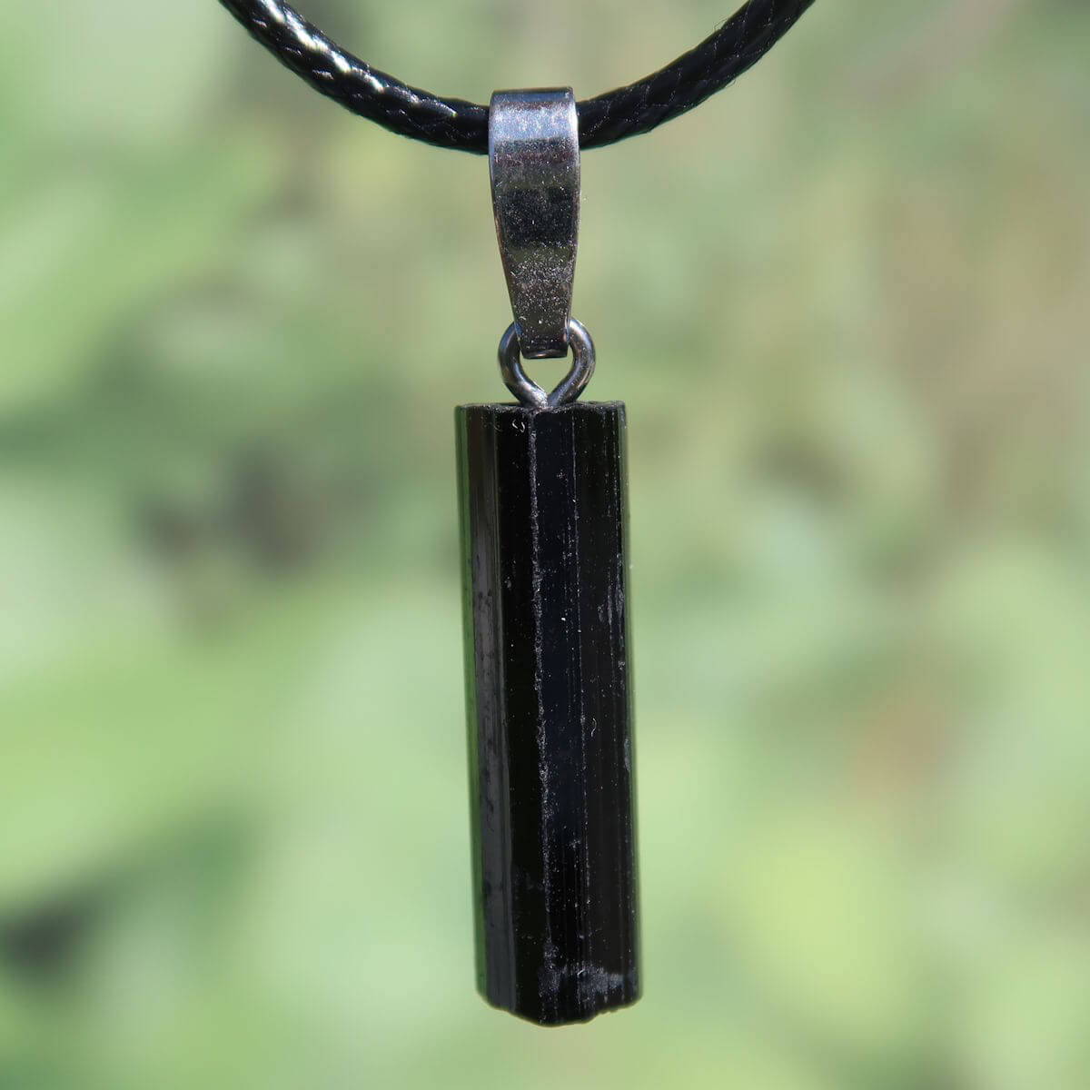 Black Tourmaline pendant with silver bail, showcasing unique natural shine and structure, 26mm length, for protection.