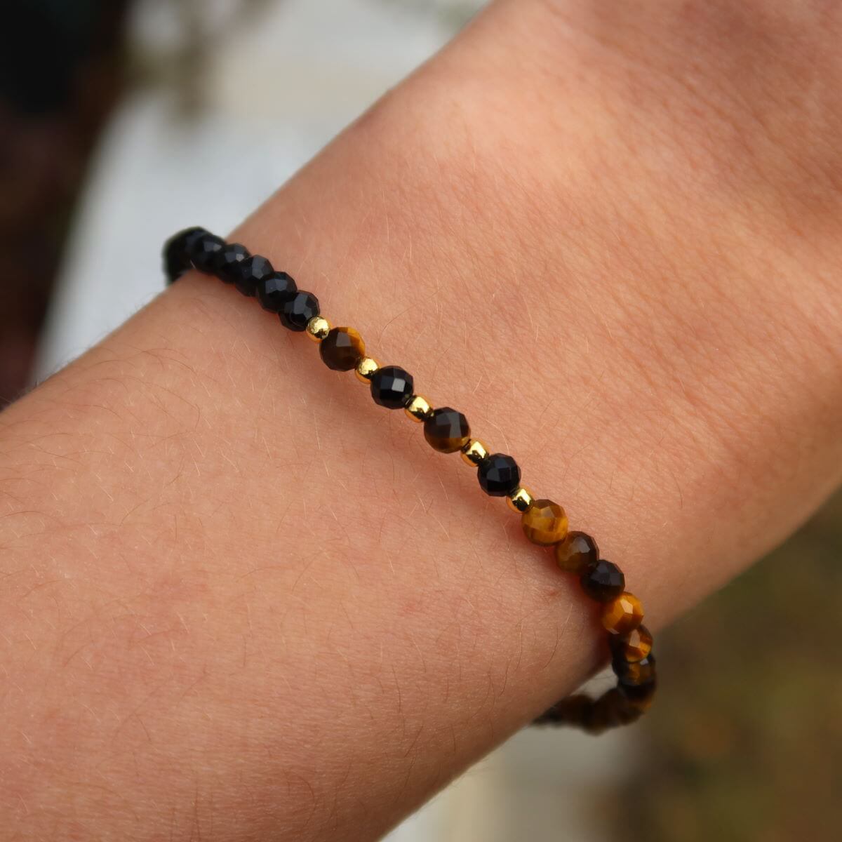 Handmade faceted tiger eye and black tourmaline gemstone bracelet on wrist, 17cm length, showcasing detailed craftsmanship and sparkling stones.