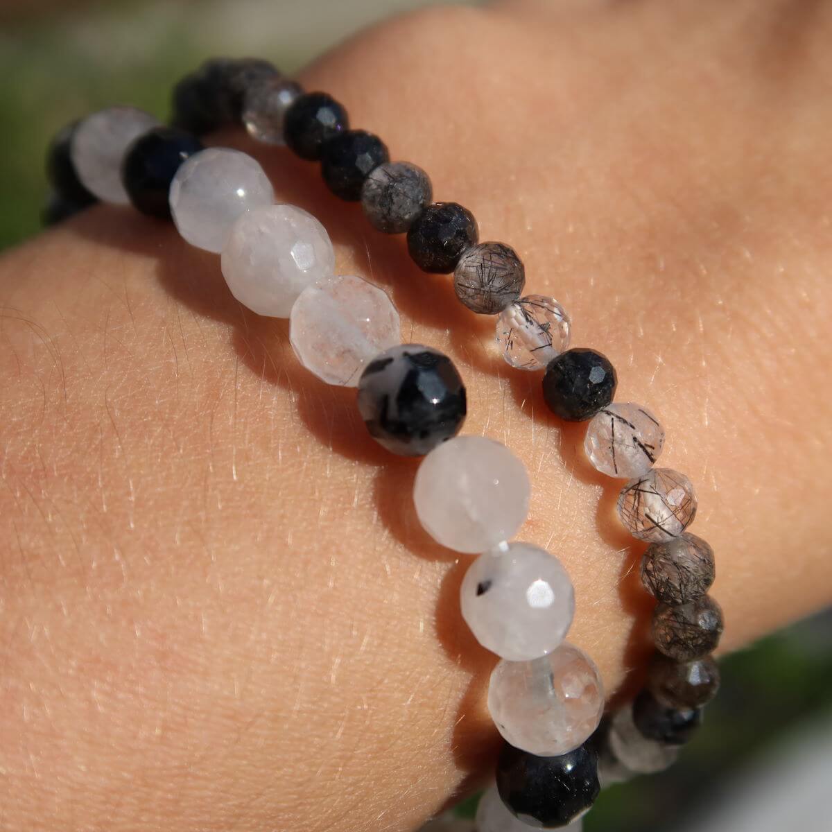 Faceted Tourmaline Quartz gemstone bracelets in varying sizes, 4-6-8mm, showcasing protective and clarifying properties on wrist.