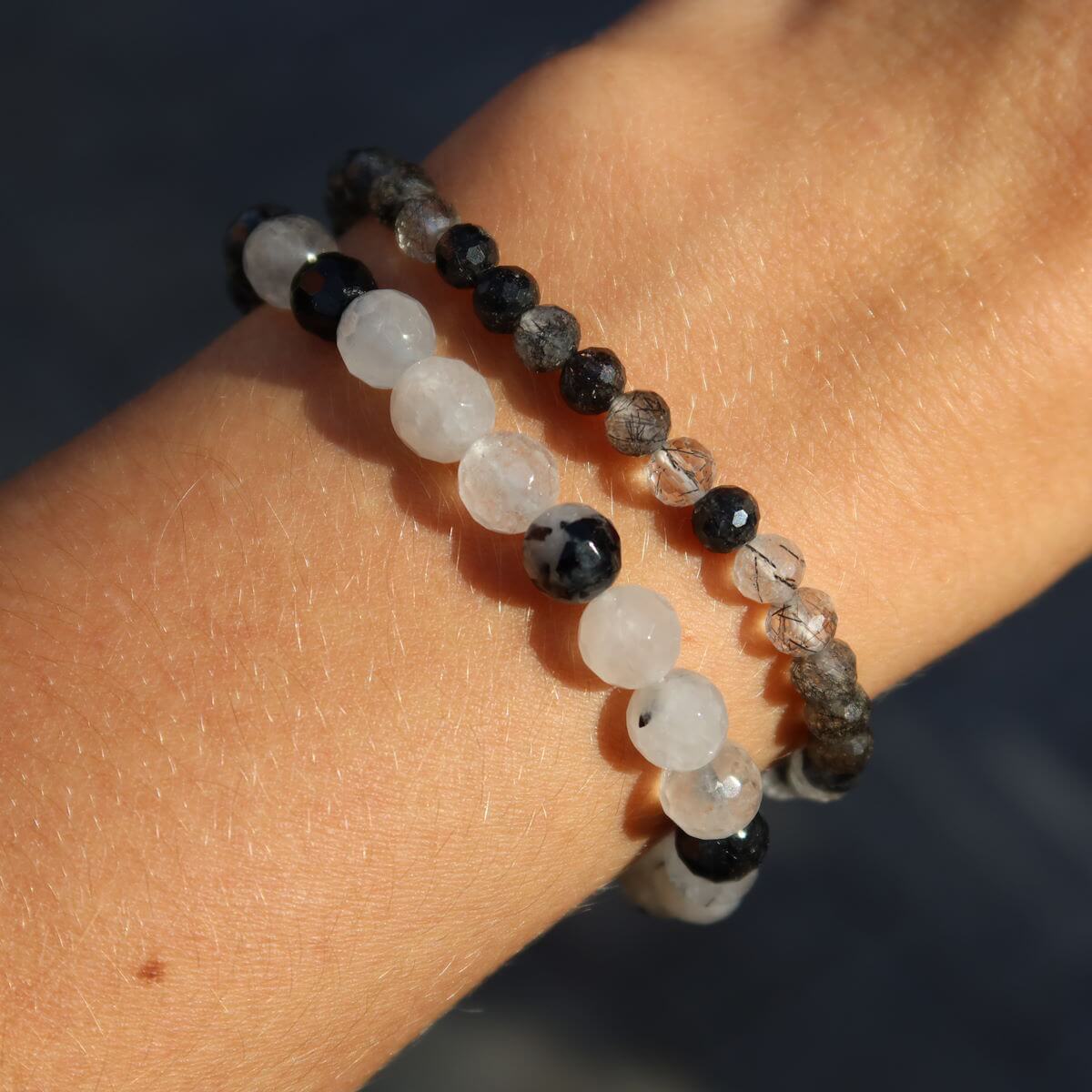 Faceted Tourmaline Quartz gemstone bracelets in varying sizes, 4-6-8mm, showcasing protective and clarifying properties on wrist.