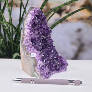 Uruguay Amethyst Mini Geode - 16x9x11cm - Harmonie und Entspannung – extra dunkler Qualität - NR 38 next to a pen.