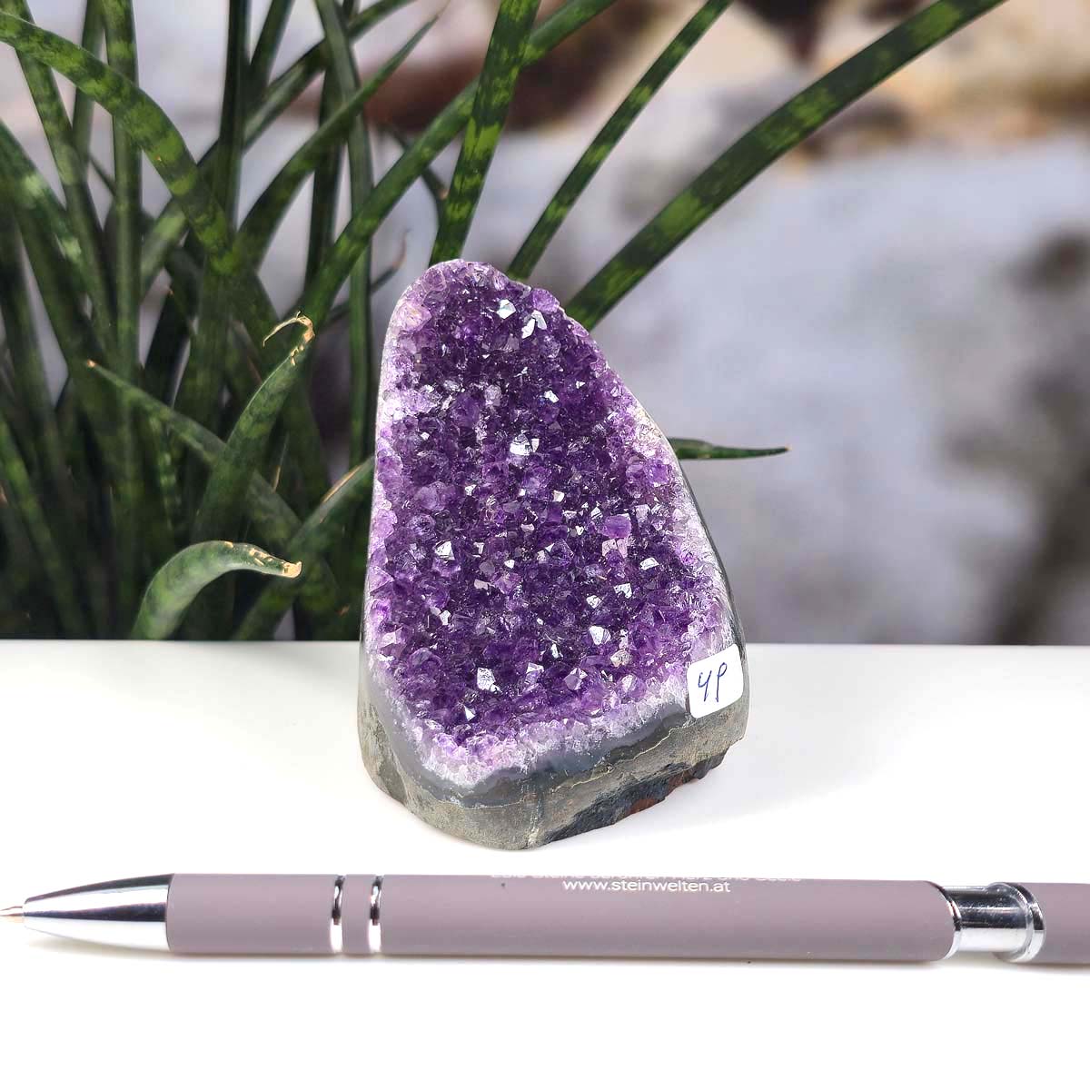 Uruguay Amethyst Mini Geode - 9x6x7cm - Harmonie und Entspannung – extra dunkler Qualität - NR 49 next to a pen on a desk.