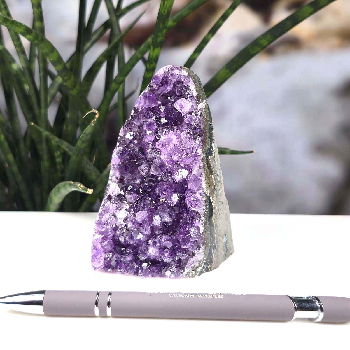 Uruguay Amethyst Mini Geode - 10x6x6cm - Harmonie und Entspannung – extra dunkler Qualität - NR 51 neben einem Stift auf weißem Hintergrund