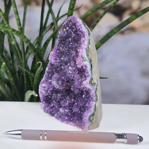 Uruguay Amethyst Mini Geode - 12x9x7cm - Harmonie und Entspannung – extra dunkler Qualität - NR 55 next to a pen.