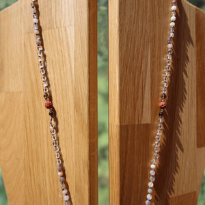 Achat mit Bergkristall und Rauchquarz geknüpfte Kette auf Holzständer, moderne Eleganz und Schutz.