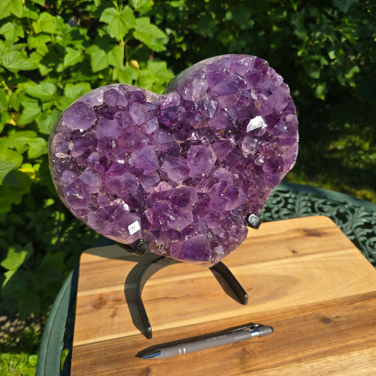 Amethyst Druse Amethyst Geode in Herzform mit Metallsockel 28x24x12cm - NR-14 auf einem Tisch mit Stift