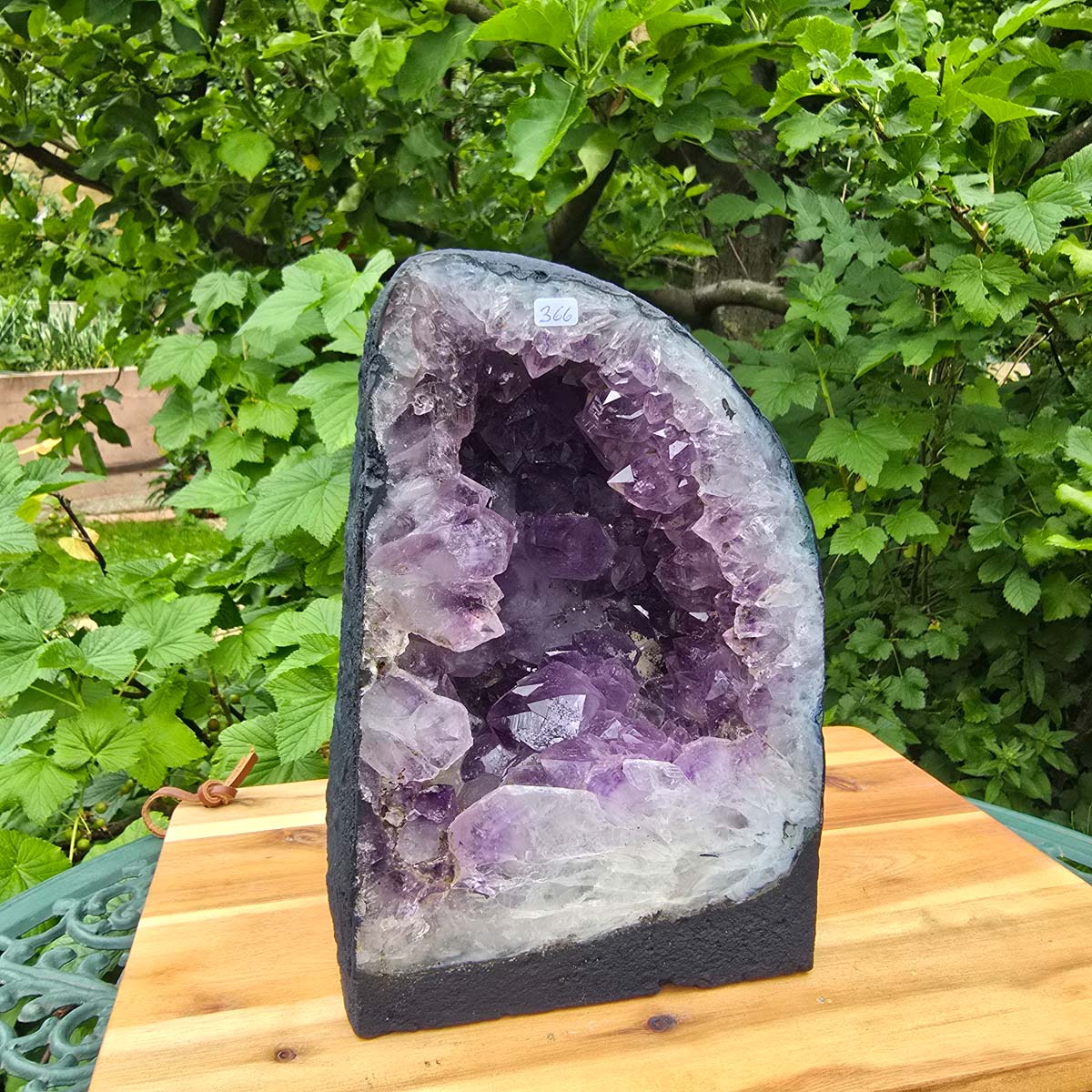 Amethyst Druse – Geode - 25x16x16cm und 10kg – Steinwelten OG - Nr. 366 auf Holzbrett im Grünen.