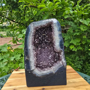 Amethyst Druse – Geode - 29x18x15cm und 11kg – Steinwelten OG - Nr. 289 auf Holzunterlage im Garten