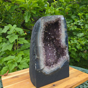 Amethyst Druse – Geode - 29x18x15cm und 11kg – Steinwelten OG - Nr. 289 auf einem Holzuntergrund.