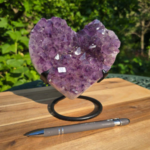 Amethyst Druse Amethyst Geode in Herzform mit Metallsockel 16x15x12cm - NR-33 auf Holzunterlage mit Kugelschreiber