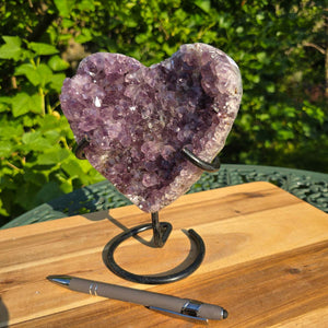 Amethyst Druse Amethyst Geode in Herzform mit Metallsockel 18x16x10cm - NR-45 auf Holzoberfläche mit Stift