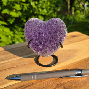 Amethyst Druse Amethyst Geode in Herzform mit Metallsockel 10x9x7cm - NR-55 auf Holzuntergrund mit Stift daneben