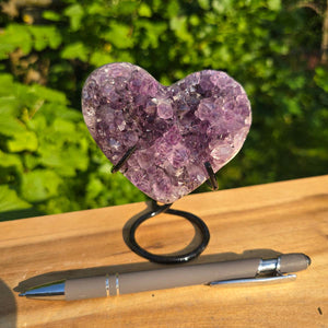 Amethyst Druse Amethyst Geode in Herzform mit Metallsockel 10x9x8cm - NR-56 auf Holzunterlage.