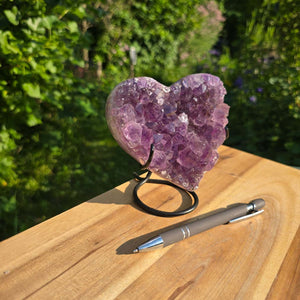 Amethyst Druse Amethyst Geode in Herzform mit Metallsockel 12x11x9cm - NR-57 auf einem Holzstamm mit Stift.