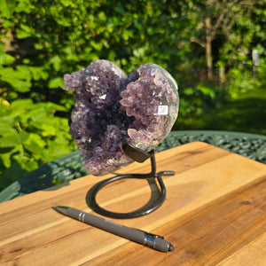 Amethyst Druse Amethyst Geode in Herzform mit Metallsockel 16x12x13cm - NR-38 auf Holzoberfläche.