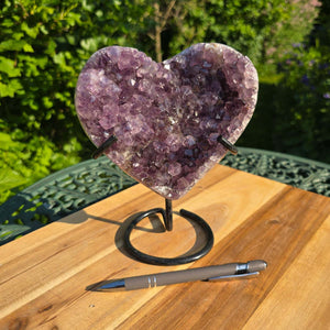 Amethyst Druse Amethyst Geode in Herzform mit Metallsockel 18x16x10cm - NR-45 auf einer Tischfläche.