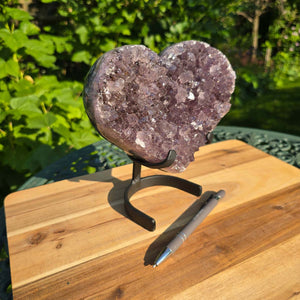 Amethyst Druse Amethyst Geode in Herzform mit Metallsockel 18x17x9cm - NR-35 auf einem Holzuntergrund.