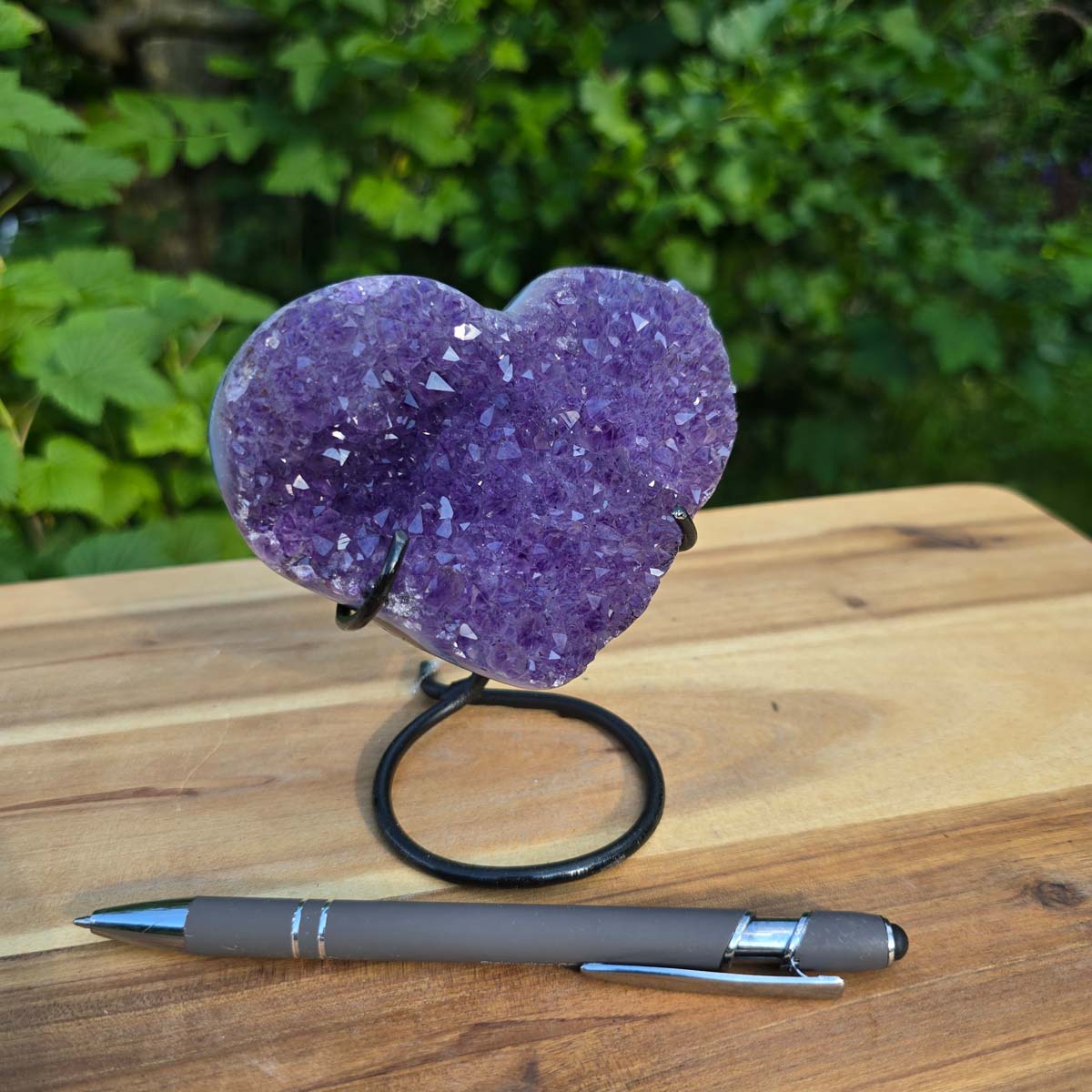 Amethyst Druse Amethyst Geode in Herzform mit Metallsockel 12x10x9cm - NR-52 auf Holztisch mit Stift