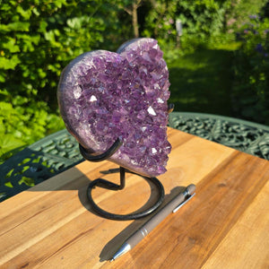 Amethyst Druse Amethyst Geode in Herzform mit Metallsockel 18x16x10cm - NR-43 auf stabiler Halterung im Freien.