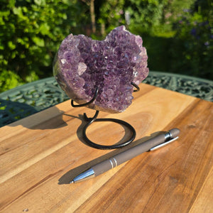 Amethyst Druse Amethyst Geode in Herzform mit Metallsockel 12x11x9cm - NR-46 auf einem Tisch mit Stift